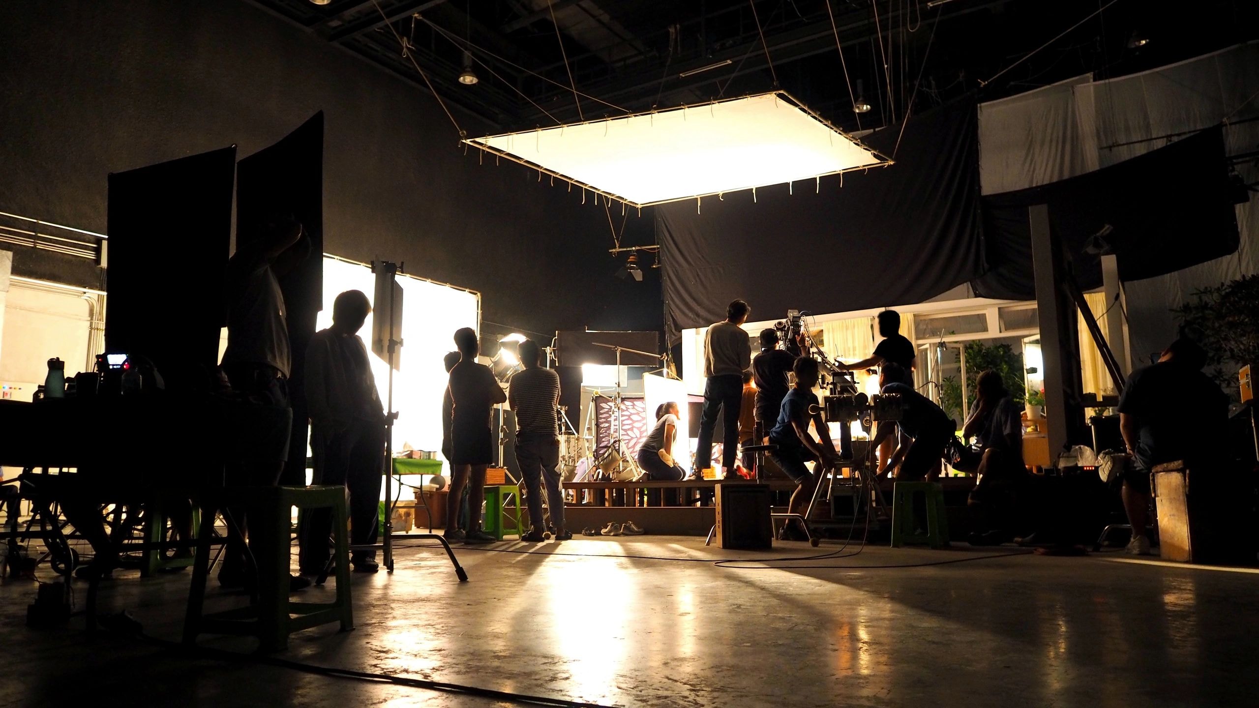 Film production set with crew and lighting rigs